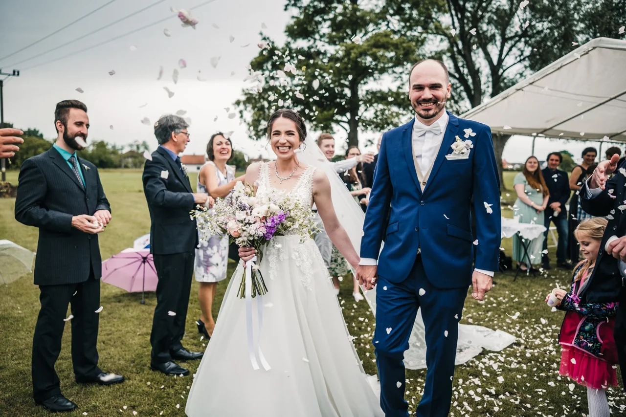 nevěsta a ženich jdou špalírem od obřadu