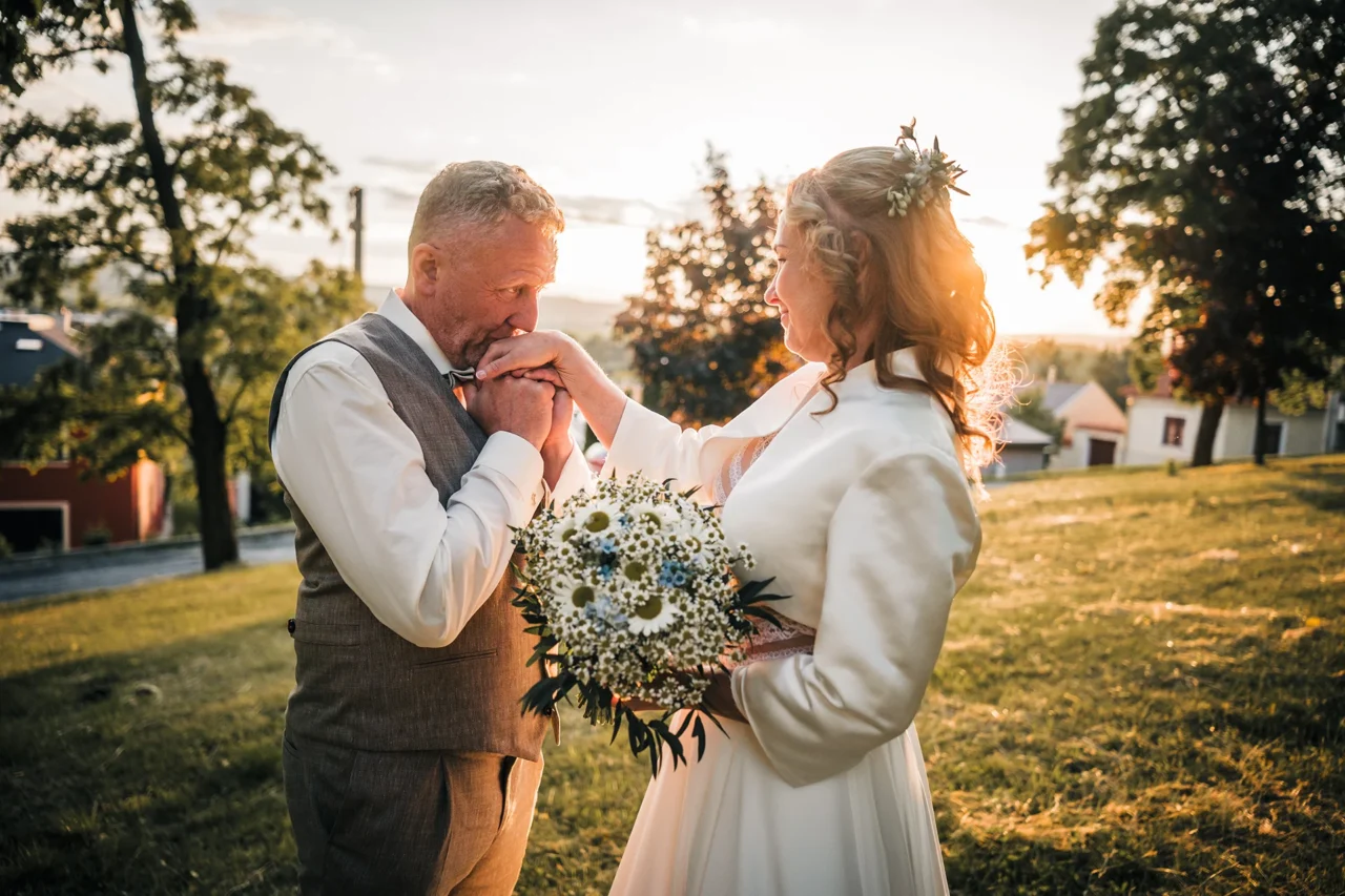 ženich dává polibek nevěstě na ruku