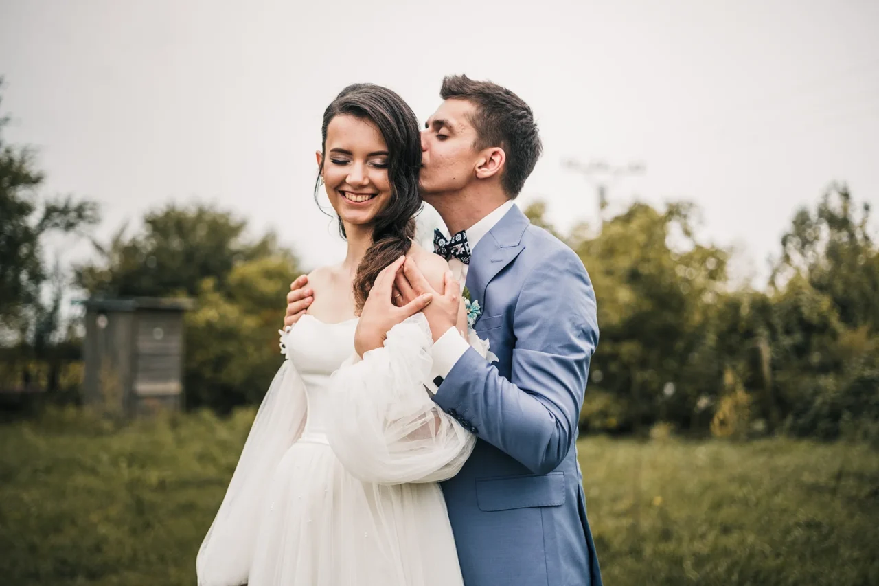 ženich dává polibek nevěste do vlasů