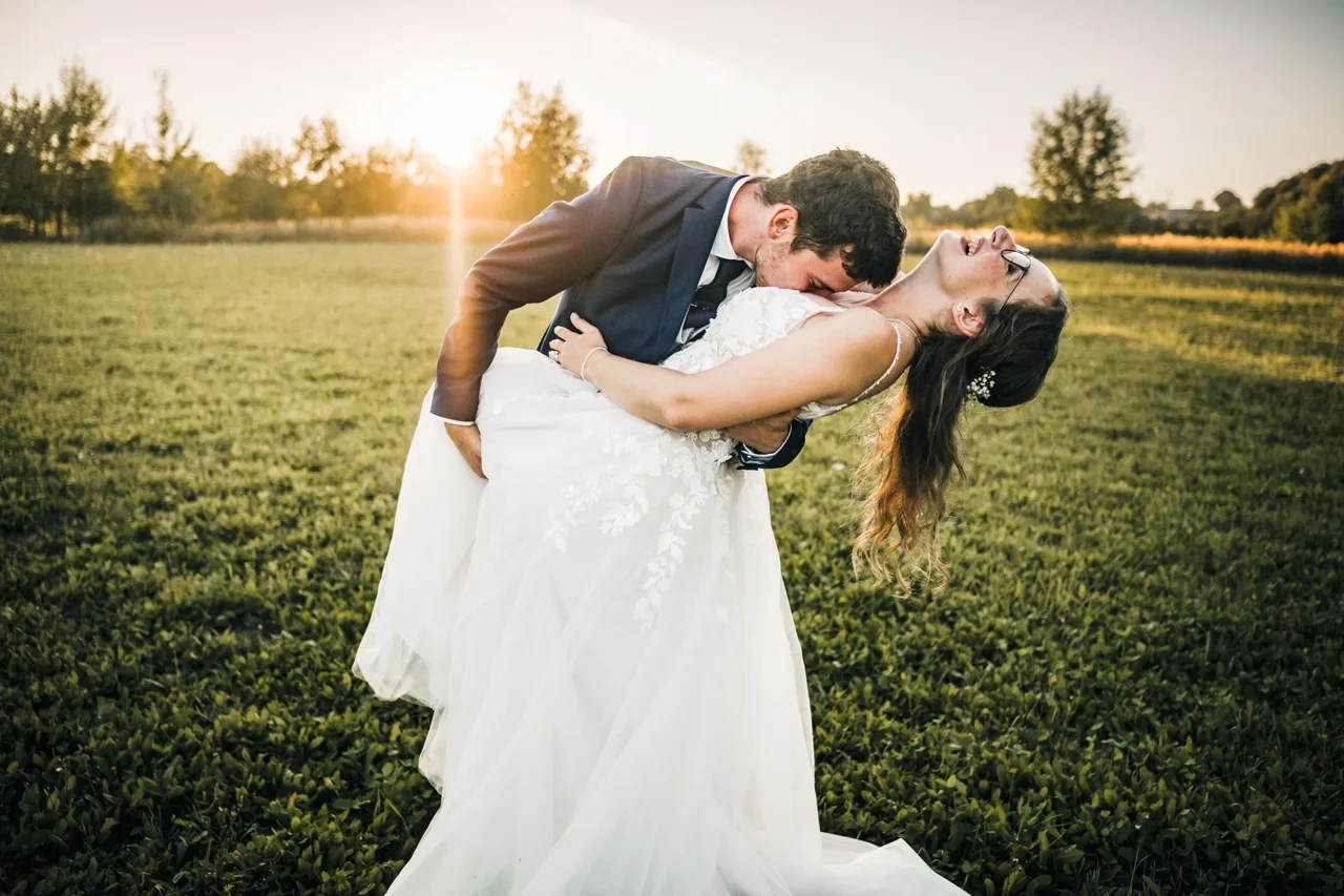 ženich dává polibek nevěstě do výstřihu